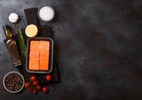 Plastic container with fresh salmon slice with oil tomatoes and lemon Stock Photos