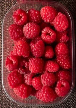 Plastic container full of fresh rasberries Stock Photos