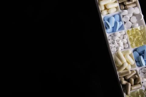 Plastic container with pills on black background Stock Photos