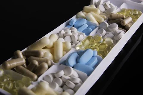 Plastic container with pills on black background Stock Photos