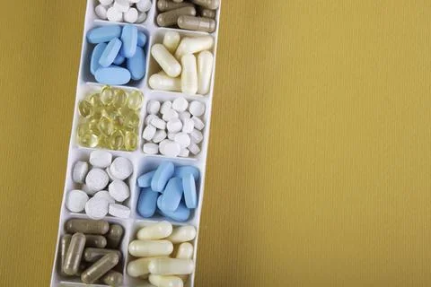 Plastic container with pills on orange background Foto stock
