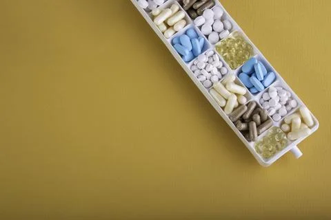 Plastic container with pills on orange background Foto stock