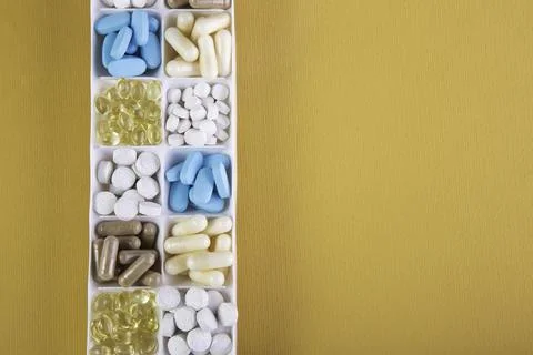 Plastic container with pills on orange background Stock Photos