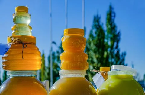 A plastic container in the shape of a bear filled with bee honey stands again Stock Photos