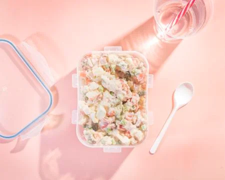 Plastic container to take away with Russian salad with a disposable plastic g Stock Photos