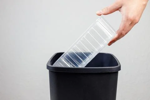 The plastic container is thrown in the trash can Stock-Fotos