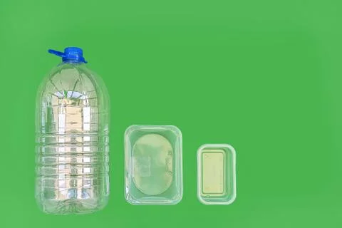 Plastic containers and bottle isolated on a green background. Plastic trash Stock Photos