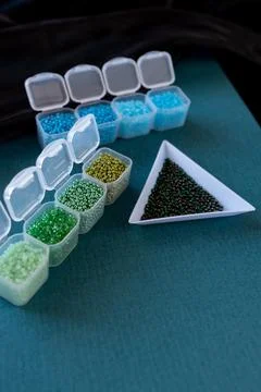 Plastic containers are filled with different colored beads Stock Photos