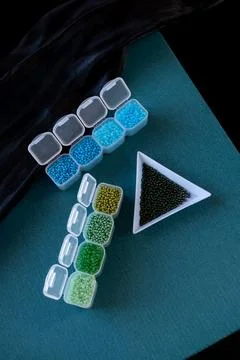 Plastic containers are filled with different colored beads Stock Photos
