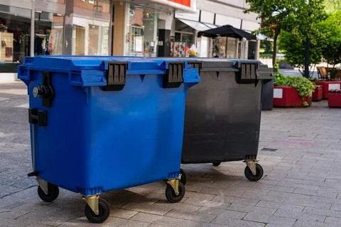 Plastic containers for collecting garbage standing in the pedestrian zone. Stock Photos