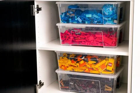Plastic containers full of blue, red, yellow and brown Lego blocks, bricks an Stock Photos