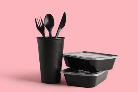 Plastic containers with takeaway paper cup and cutlery on pink background Stock Photos