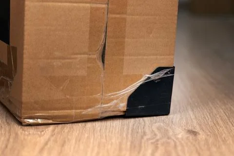 Plastic corner guard attached with clear tape to a cardboard box for protec.. Stock Photos