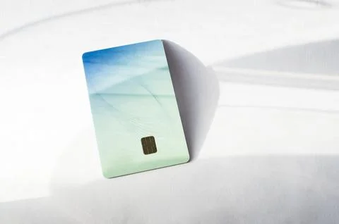 Plastic credit card with chip visible, on top of a table with soft lights and 库存照片
