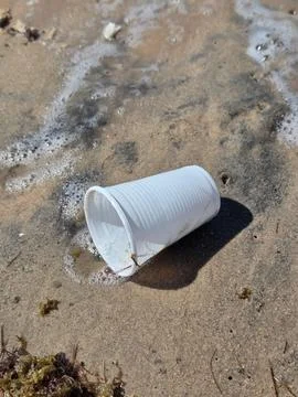 Plastic cup discarded in the sand Stock Photos
