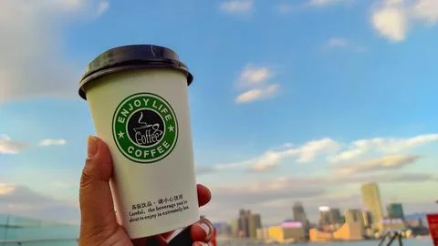 Plastic cup "Enjoy live coffee" Stock Photos