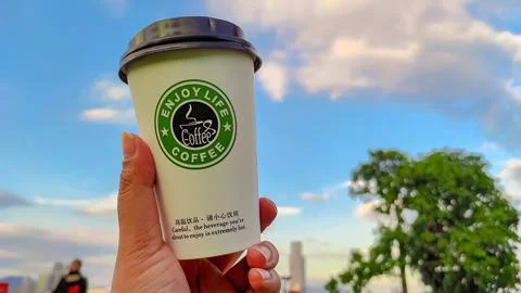 Plastic cup "Enjoy live coffee" Stock Photos