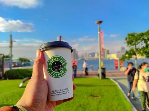 Plastic cup "Enjoy live coffee" Stock Photos