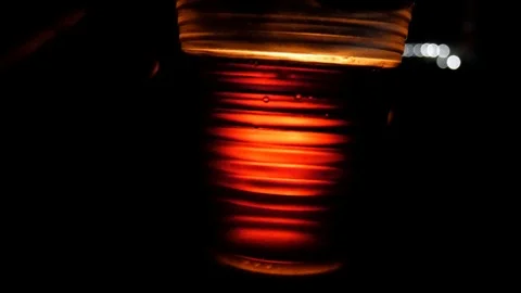 Plastic cup filled in with red beverage is flickering on the fire background Stock Footage 113742897