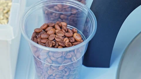 Plastic Cup Full of Brown Freshly Roasted Coffee Beans Video stock 235626911