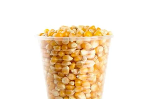 Plastic cup full of corn seeds on white background Stock Photos