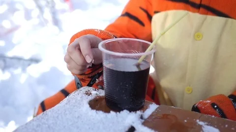 Plastic cup with hot mulled wine on a snowy table, slow motion Stock Footage 71006942