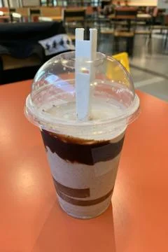 Plastic cup with milk shake on the table in a bar close-up Stock Photos