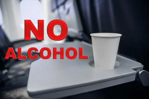 Plastic cup on the table in the plane during the flight. alcohol consumption  Stock Photos