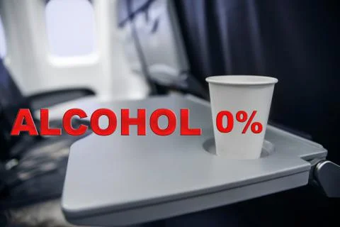 Plastic cup on the table in the plane during the flight. alcohol consumption  Stock Photos