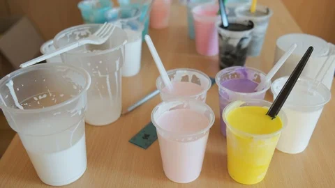 Plastic cups with acrylic paint on the table. Stock Footage 106359815