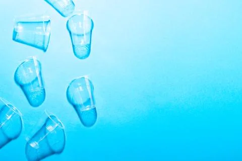Plastic cups on blue background. Stock Photos