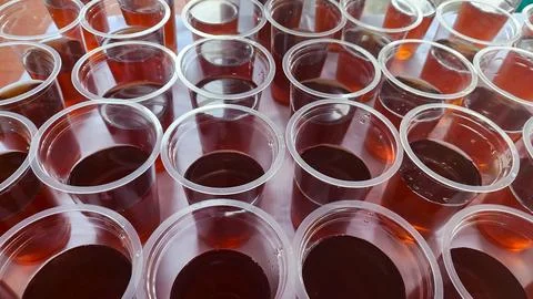 Plastic cups of tea in a row, close-up Stock Photos