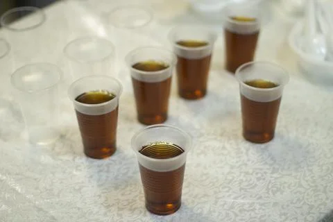 Plastic cups with tea. Tea for guests. Free distribution of hot drinks. Stock Photos