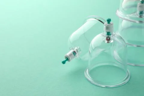 Plastic cups on turquoise background, space for text. Cupping therapy Stock Photos