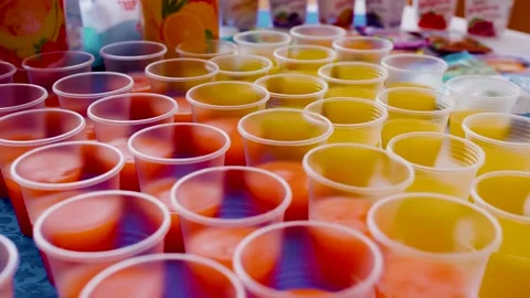 Plastic cups with yellow and red drink. Stock Footage 135786411