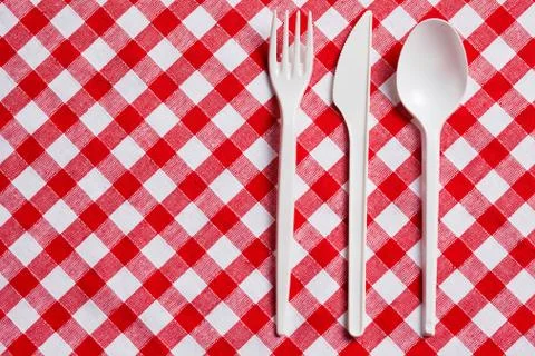 Plastic cutlery on checkered tablecloth Stock Photos
