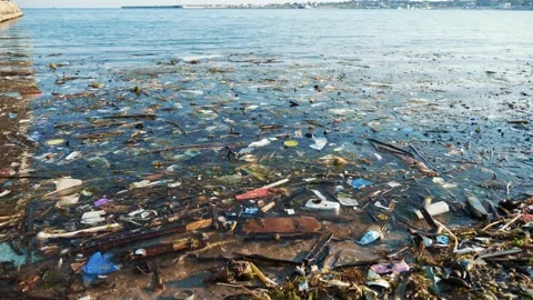 Plastic debris on blue sea surface. Polluted beach. Garbage, bottles and other Stock Footage 194485070
