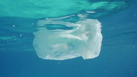 Plastic debris drifts under surface of sea, slow motion Stock Footage 234793159