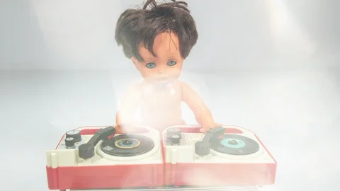 Plastic doll djing on toy record player. Video stock 129302294