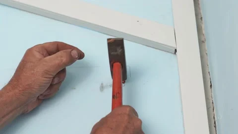 A plastic dowel is inserted into the wall, a chip and hammered with a hammer. Stock Footage 203852089
