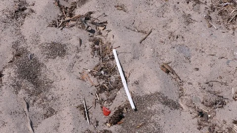Plastic drinking straws litter the beach by the water Stock Footage 92106095