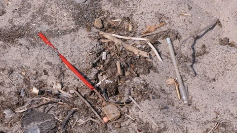 Plastic drinking straws litter the beach by the water Stock Footage