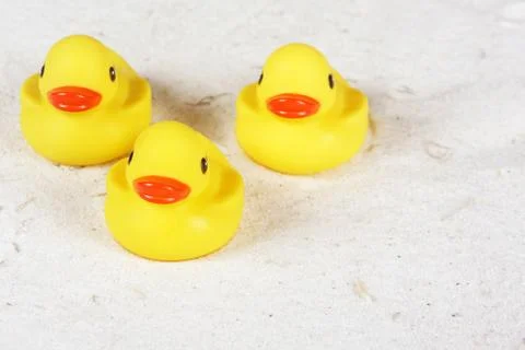 Plastic ducks in the sand with copy space Stock-Fotos