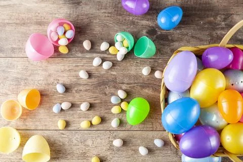 Plastic easter eggs being filled with chocolates before easter egg hunt. Stock Photos