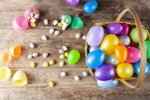 Plastic easter eggs being filled with chocolates before easter egg hunt. Stock Photos