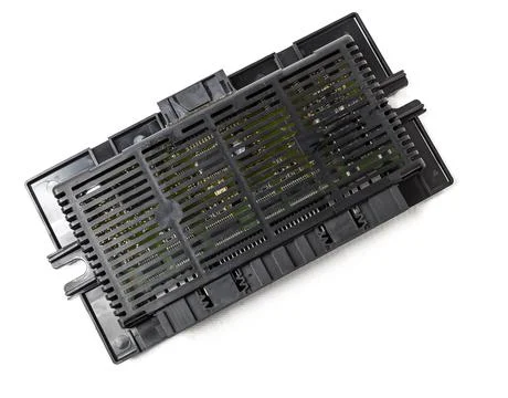 Plastic electronic control unit with black and blue connectors on a white iso Stock Photos