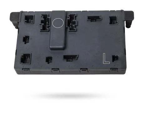 Plastic electronic control unit with black and blue connectors on a white i.. Stock Photos