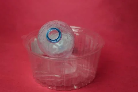 Plastic empty bottle in container on red background, space for text. Concept  Stock Photos