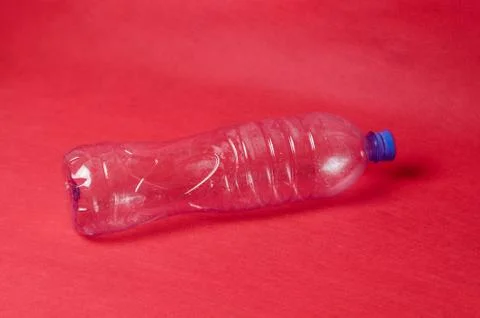 Plastic empty bottle on a red background with space for text. Concept of envi Stock Photos