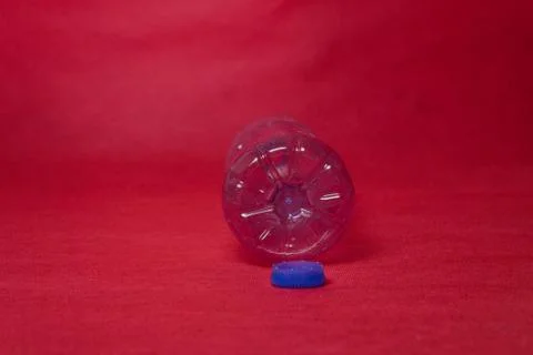 Plastic empty bottle on a red background with space for text. Concept of envi Stock Photos